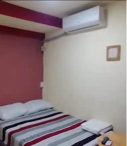 a bedroom with a bed with a red wall at Comfort Home Escalón in San Salvador