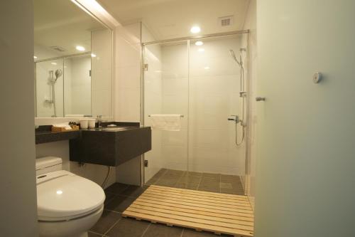 uma casa de banho com um chuveiro, um WC e um lavatório. em IlleInn Hotel em Seogwipo