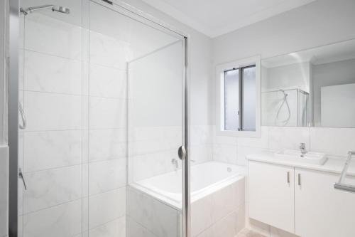 a white bathroom with a shower and a sink at Mt Baker Home:10km to Hahndorf in Mount Barker