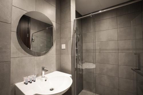a bathroom with a sink and a mirror at K Avenue by Pinstay in Donggongon