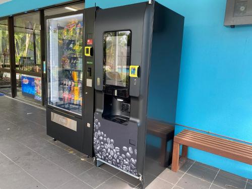 a drink vending machine next to a bench next to a building at Nobby Beach Holiday Village in Gold Coast
