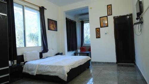 sypialnia z łóżkiem i dużym oknem w obiekcie Hotel Vardan - Ayur Stay w mieście Bijni