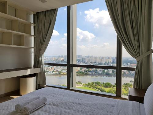 Vinhomes Central Park Apartment- Landmark Luxury في مدينة هوشي منه: غرفة نوم مع نافذة كبيرة مطلة على نهر