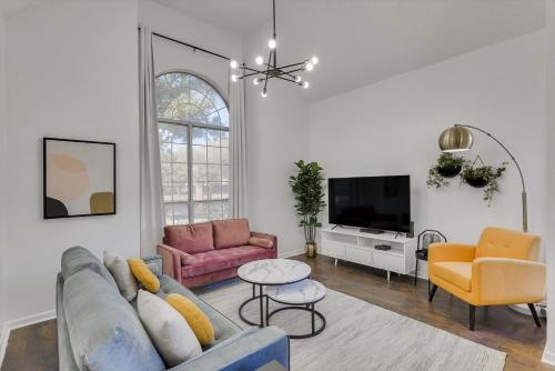 a living room with a couch and a tv at Luxury Holiday Home 5BR Hot Tub, Pool & Beautiful Backyard in Grand Prairie