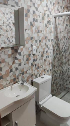 a bathroom with a toilet and a sink and a mirror at Residência Da Família Binitz in Visconde De Maua