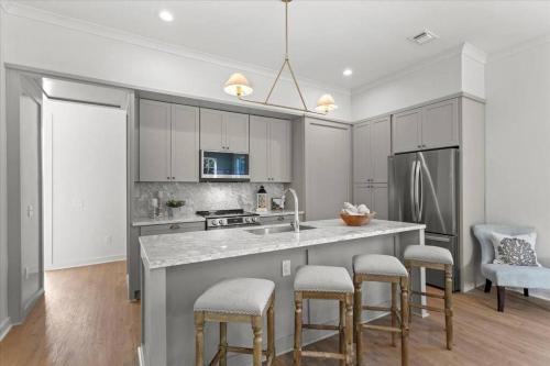 a kitchen with a large island with bar stools at Cat Island Town Home in Pass Christian