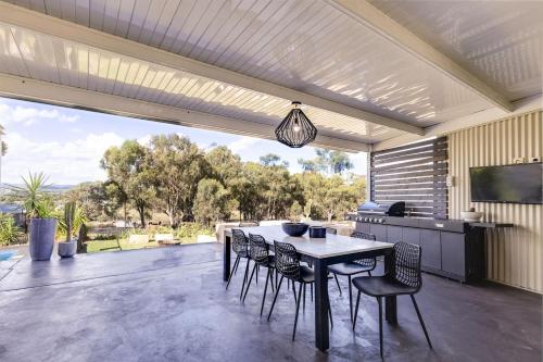 a dining area with a table and chairs on a patio at The Albens - Countryside Chic amongst the Hills in Mudgee
