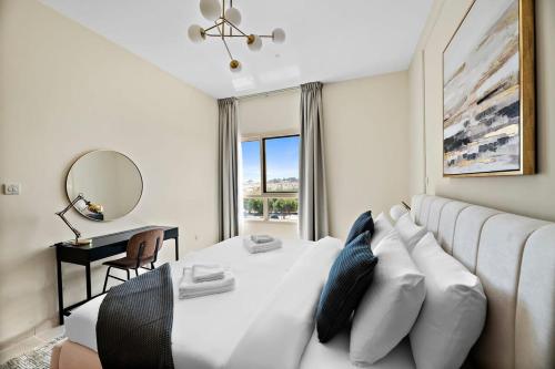 - un salon avec un canapé blanc et un miroir dans l'établissement Silkhaus The Greens neighborhood newly furnished 1BDR, à Dubaï