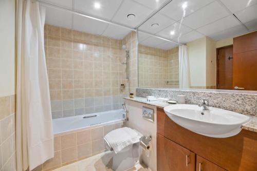 łazienka z umywalką, toaletą i wanną w obiekcie Silkhaus The Greens neighborhood newly furnished 1BDR w Dubaju