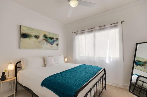 a white bedroom with a bed with a blue blanket at The Albens - Countryside Chic amongst the Hills in Mudgee