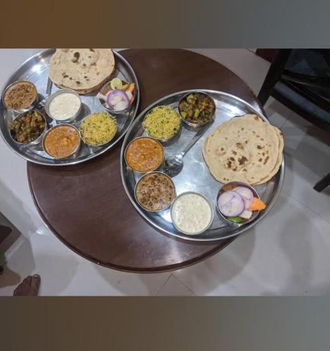 - une table avec deux plateaux de nourriture dans l'établissement Royal Aryan Hotel, à Purî