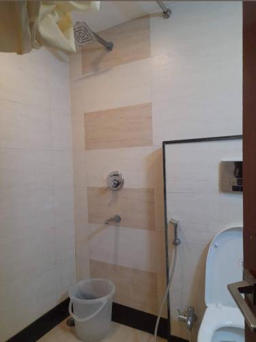 La salle de bains est pourvue d'une douche et de toilettes. dans l'établissement Royal Aryan Hotel, à Purî