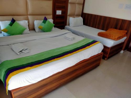 two beds in a room with green and colorful sheets at Sky Pie hotel in Dharamshala