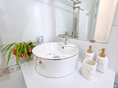 a white bathroom with a sink and a mirror at Mui Ne Sunlight Villa in Mui Ne