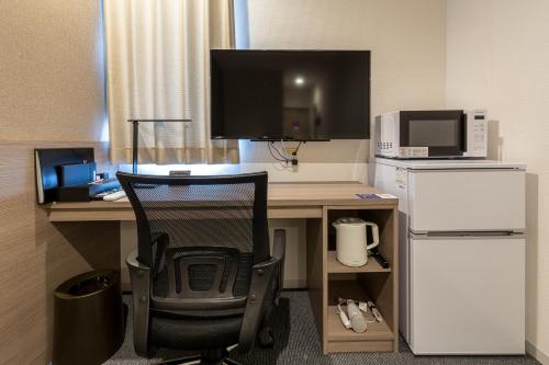 a desk with a computer and a chair in a room at HOTEL R9 The Yard Hitachinakaichige in Hitachinaka