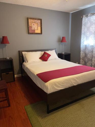 Un dormitorio con una cama con una almohada roja. en Cozy Home with Sparkling Pool/Pet Friendly en Mesa