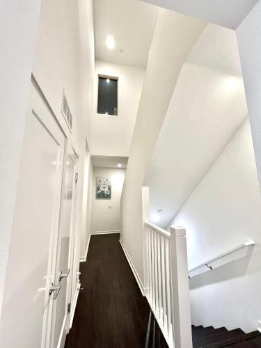 a hallway with white walls and a staircase with a door at Casa Dolce Vita - Luxury Modern Stays - Flexible Monthly Arrangements Available 30-Night Minimum in Irvine