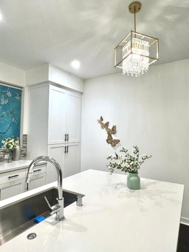 a kitchen with a sink and a chandelier at Casa Dolce Vita - Luxury Modern Stays - Flexible Monthly Arrangements Available 30-Night Minimum in Irvine