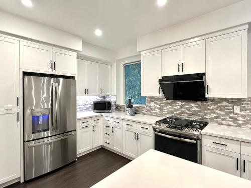 a kitchen with white cabinets and stainless steel appliances at Casa Dolce Vita - Luxury Modern Stays - Flexible Monthly Arrangements Available 30-Night Minimum in Irvine