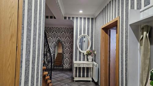 a hallway with blue and white striped walls and a mirror at Apartment Tbilisi View in Tbilisi City