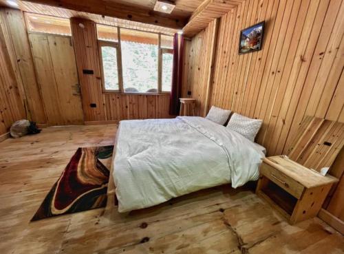 um quarto com uma cama num quarto de madeira em Golden heritage dharali (harsil) em Harsil