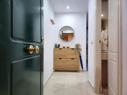 ein Badezimmer mit einem Spiegel und einer Holzkommode in der Unterkunft Apartment Beachfront Accommodation in Estepona