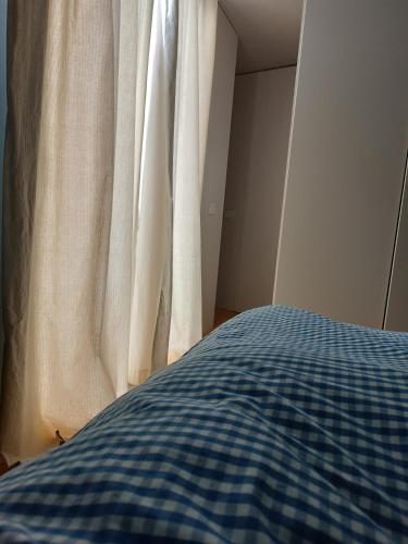 - une chambre avec un lit bleu et blanc et une fenêtre dans l'établissement Vico dei fiori, à Acireale