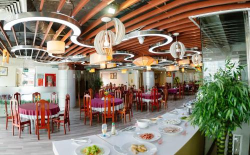 a dining room with tables and chairs and chandeliers at Kim Tho Hotel in Can Tho