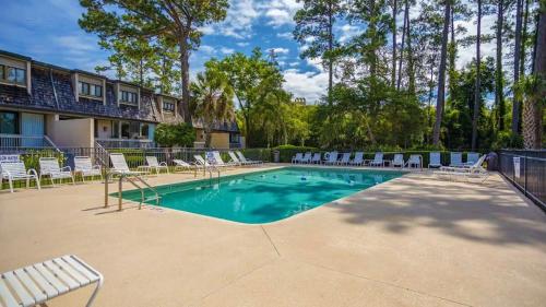 a swimming pool with lounge chairs at Harbour Town Haven Spacious 4Bd 4Ba Retreat in Hilton Head Island