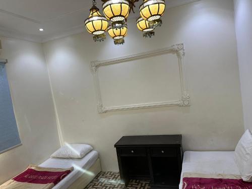 a room with two beds and a mirror and chandeliers at Al Badeel Hotel in Medina