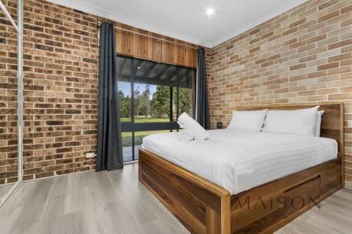 a bedroom with a bed with a brick wall at Family Getaway in Salt Ash in Salt Ash