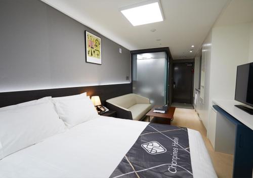 a hotel room with a bed and a television at Sokcho Chonpines Beach Hotel in Sokcho