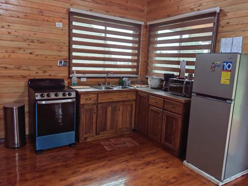 uma cozinha com fogão e frigorífico numa cabina em Cabaña El Sueño em Cartago