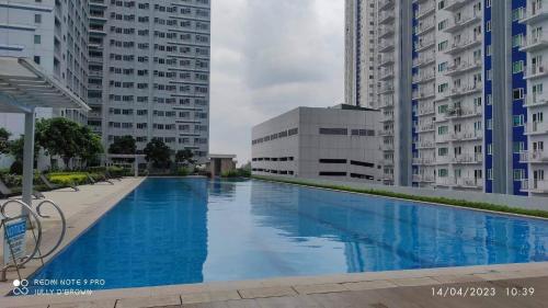 una gran piscina en una ciudad con edificios altos en Grass Residence Sm North Edsa Tower 3, en Manila