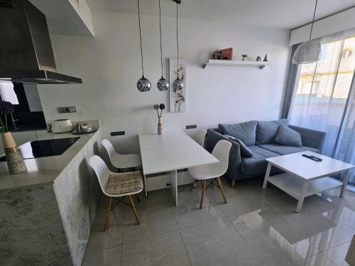 een keuken en woonkamer met een tafel en een bank bij Apartment Margarita 2 in Torrevieja
