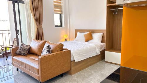 a bedroom with a bed and a couch and a window at Sea Flower Homestay in Quy Nhon