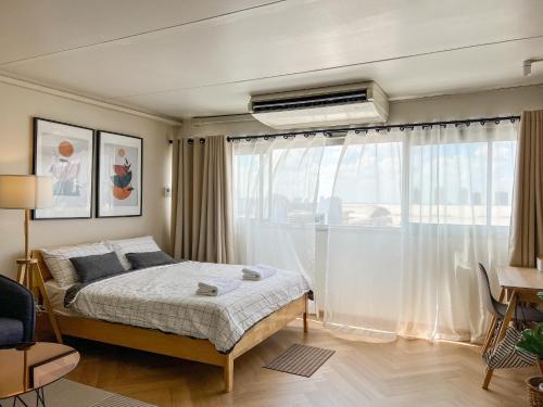 ノンタブリーにあるBetter Room ห้องพักรายวัน เมืองทองธานี C5のベッドと大きな窓のある寝室