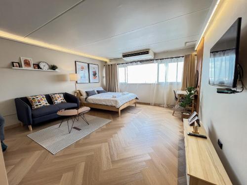 a living room with a couch and a tv at Better Room ห้องพักรายวัน เมืองทองธานี C5 in Nonthaburi