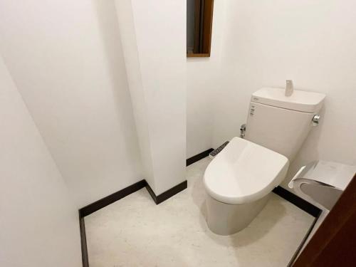 a bathroom with a white toilet in a room at bHOTEL Kaniwasou 301 Minute walk from Miyajima Pier for 11ppl in Miyajima