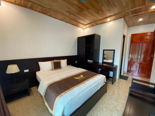 sypialnia z dużym łóżkiem z biurkiem i łóżkiem o wymiarach 6 x 6 x 6 x 6 w obiekcie Nhà nghỉ Giang Sơn w mieście Bac Ha