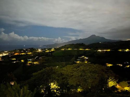 a view of a city at night with a mountain at Villa Indigo in Le Carbet