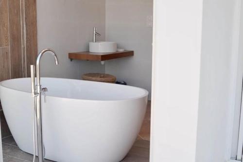 a white bath tub in a bathroom with a sink at Villa Indigo in Le Carbet