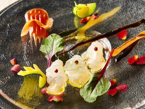 a plate of food on a table with food at Hotel Shigira Mirage Beach Front in Miyako Island
