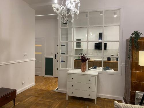a living room with a white cabinet and a chandelier at Tabago Studio 16 in Nysa