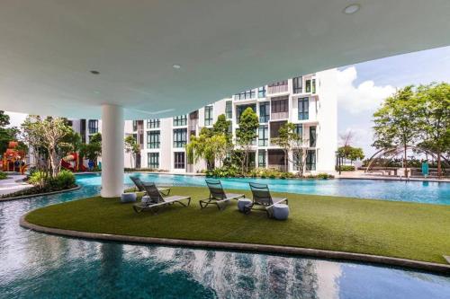 una piscina con sillas y un edificio en H20 residence studio high floor, en Petaling Jaya