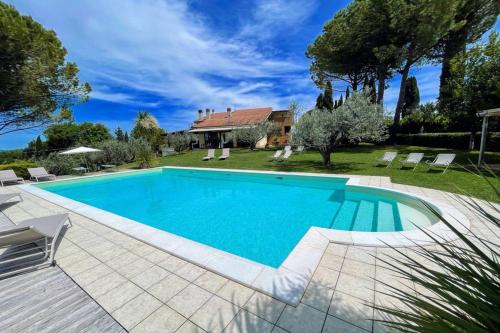 uma piscina em frente a uma casa em Villa between Montefalco and Bevagna - 3 kms walk to shops, bars and restaurants em Belvedere