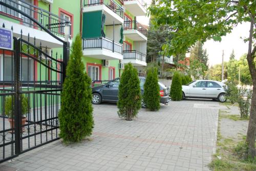 a parking lot with cars parked in front of a building at Apartments Villa Zora in Star Dojran