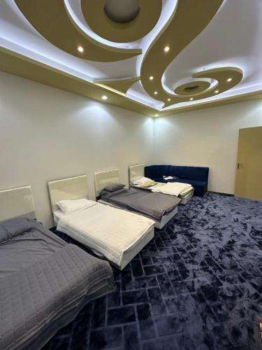 3 camas en una habitación con techo artesonado en شاليه هاشتاق الودي, en Al Wudayy