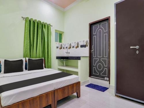 a bedroom with a bed and a door at OYO Shri Radhe Guest House & Restaurant in Rishīkesh