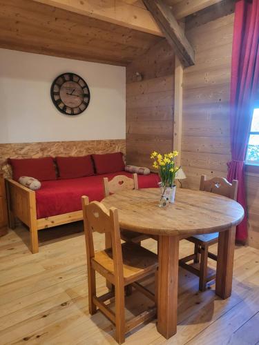 a living room with a wooden table and a couch at Le Nid des Cerfs in Essert La Pierre